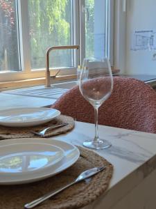 a table with a glass of wine on a table at Maison H - Logement de luxe avec jacuzzi privé et home cinéma immersif in Herstal