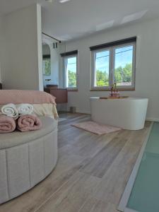 a bathroom with a tub and a bed and a sink at Maison H - Logement de luxe avec jacuzzi privé et home cinéma immersif in Herstal +4 photos