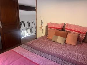 a pink bed with pillows on it in a room at Villa LA BELLE ETOILE in Étoile-sur-Rhône