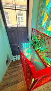 a red chair in front of a door with a window at Arts Hotel Tbilisi in Tbilisi City