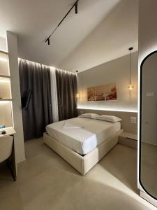 a bedroom with a white bed and a window at Ionian Rooms in Vlorë +24 photos