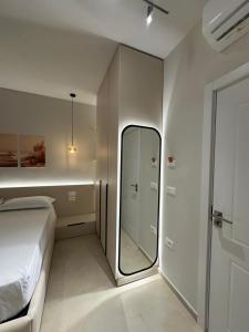 a bedroom with a bed and a mirror in it at Ionian Rooms in Vlorë
