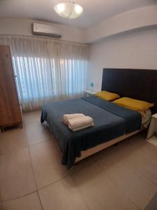 a bedroom with a large blue bed with yellow pillows at Quartier San telmo Piscina climatizada y Spa premium in Buenos Aires +40 photos
