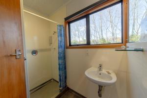 a bathroom with a sink and a window and a shower at Geraldine Motels in Geraldine +24 photos