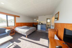 a bedroom with a bed and a flat screen tv at Geraldine Motels in Geraldine
