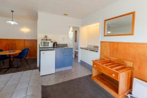 a room with a bed and a kitchen with a table at Geraldine Motels in Geraldine