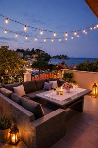 a patio with a couch and a table with lights at Apartment Lučka II in Banjol