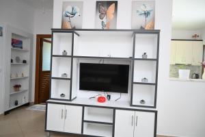 a white entertainment center with a flat screen tv at Villa Nertili 1 in (( Kalive Gjoka )) +13 photos