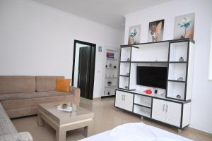 a living room with a couch and a flat screen tv at Villa Nertili 1 in (( Kalive Gjoka ))