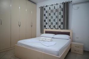 a bedroom with a bed with white sheets and pillows at Villa Nertili 1 in (( Kalive Gjoka ))