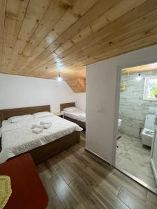 a bedroom with a large bed and a wooden ceiling at Bujtina Sherifaj in Valbonë