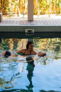 a woman swimming in a swimming pool at Samaraya Wellness Resort - Adults Only in Lipa Noi