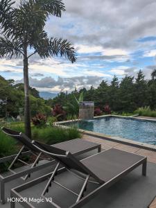 a table and chairs next to a swimming pool at La Parada House 25 in Concepción