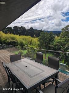 a table and chairs on a wooden deck with a view at La Parada House 25 in Concepción