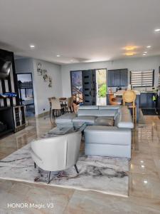 a living room with white couches and a kitchen at La Parada House 25 in Concepción