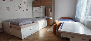 a bedroom with a bed and a desk and a table at Chaloupka v srdci památkové zóny in Putím +3 photos