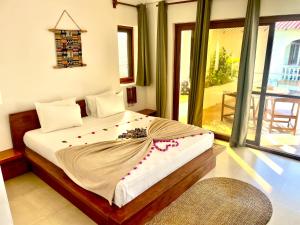 a bedroom with a large bed with flowers on it at Aluna Beach Apartments in Nungwi