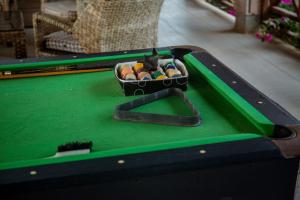 a container of pool balls on a pool table at Villa Miradie in Grand-Bassam
