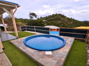 a swimming pool in the middle of a yard at Les Cocons des Alizés in Sainte-Anne