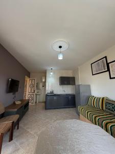 a living room with a couch and a kitchen at Villa le Palmier in Saïdia