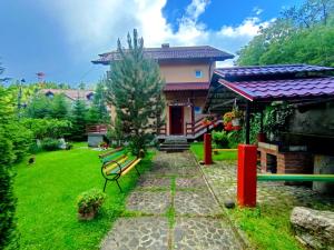 a house with a bench in front of a yard at CASA de VIS in Sinaia