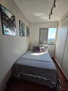 a small bedroom with a bed in the corner at Apartamento 2 Quartos Moderno in Belo Horizonte