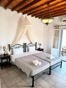a bedroom with a large bed and a chandelier at Studios Poulati in Artemonas