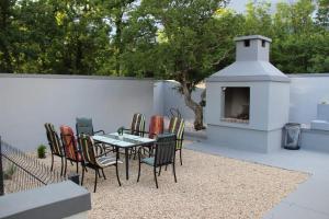 a patio with a table and chairs and a fireplace at Villa Martar in Mostar