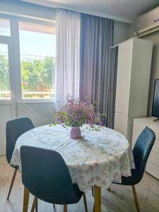 a dining room table with a vase of flowers on it at Guest House Medusa - Old town in Pomorie