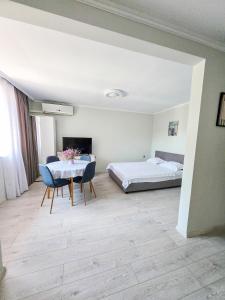 a bedroom with a bed and a table and chairs at Guest House Medusa - Old town in Pomorie
