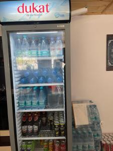 a refrigerator filled with lots of bottles of water at Hostel Sherifaj in Valbonë