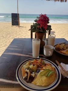 a table with a plate of food on the beach at La Máxima Drag Show & Bar LGBT in Zipolite