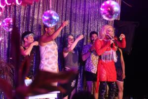 a group of people standing on a stage holding bubbles at La Máxima Drag Show & Bar LGBT in Zipolite