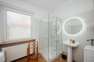a white bathroom with a shower and a sink at Willa Berg Cieplice in Jelenia Góra +15 photos