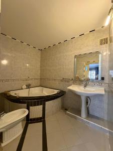 a bathroom with a tub and a sink at Villa le Palmier in Saïdia +30 photos