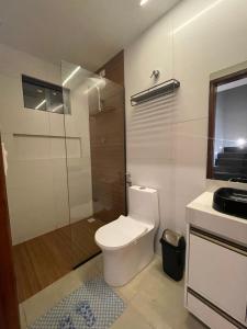 a bathroom with a toilet and a glass shower at Flat do Lucca 02 - Piscina - 50m da Praia - Até 10 Pessoas in Tamandaré