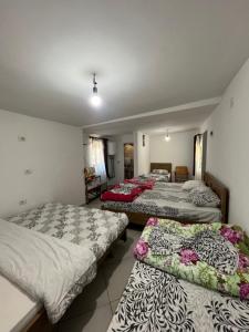 a room with three beds and a room with at Hostel Sherifaj in Valbonë