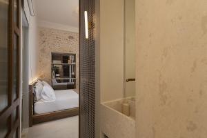 a small bedroom with a bed and a mirror at Bliss House in Rethymno
