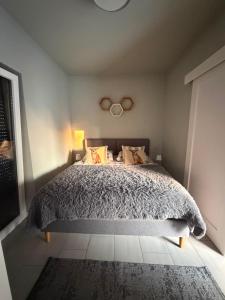 a bedroom with a bed with a gray comforter at Domki za Wyspą in Chmielów