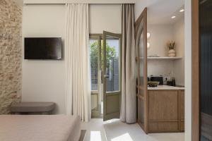 a bedroom with a bed and a kitchen with a window at Bliss House in Rethymno +61 photos