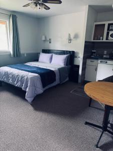a bedroom with a large bed and a table at Sunset Motel in Radium Hot Springs