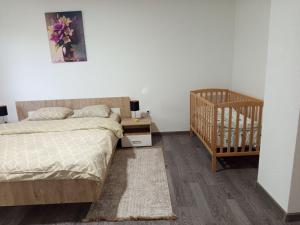a bedroom with a bed next to a crib and a crib at Japodska Oaza in Bihać