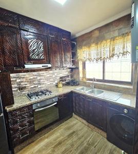 a kitchen with wooden cabinets and a sink and a window at Ray CaboNegro Sea & Pool View in Cabo Negro