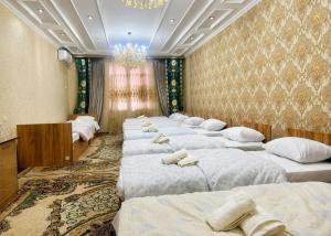 a row of beds in a large room with a chandelier at Marshall in Termiz