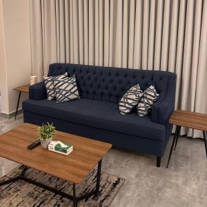 a blue couch in a living room with a table at وحده خاصة بمدخل مباشر s1 in Al Kharj