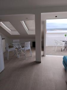 a room with a table and chairs and a view of the ocean at Apartmani Deluxe in Jasenice