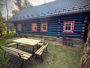 a blue house with a picnic table in front of it at Chalupa Jaseň in Ždiar