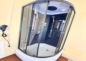 a shower with a glass door in a room at Marshall in Termiz