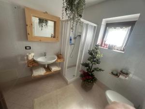 a white bathroom with a sink and a shower at Casa Cappuccetto in Imer +6 photos