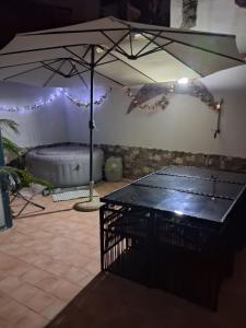 a ping pong table in a room with an umbrella at Appartamento Claudia in Roccalumera